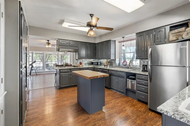 a kitchen with granite countertop stainless steel appliances and wooden cabinets