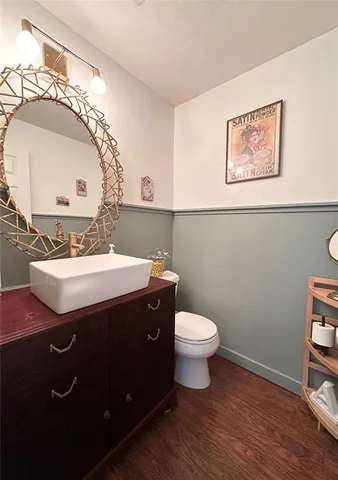 a bathroom with a toilet a sink and mirror