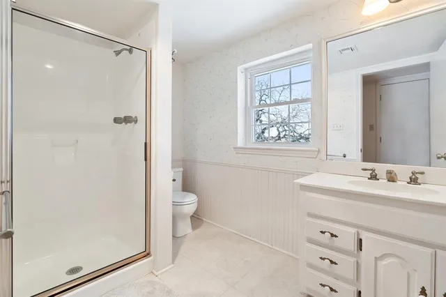 a bathroom with a sink a toilet and shower