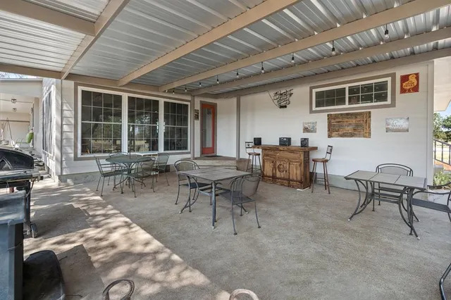 a view of a patio with table and chairs and potted plants