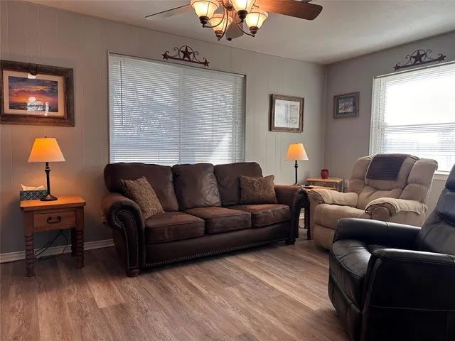 a living room with furniture a window and a lamp
