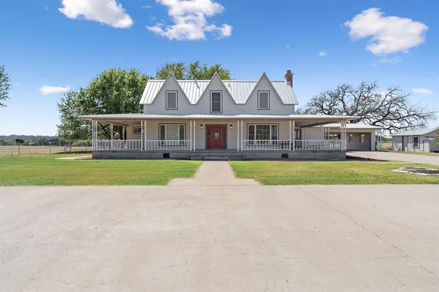 a view of house with a big yard and potted plants