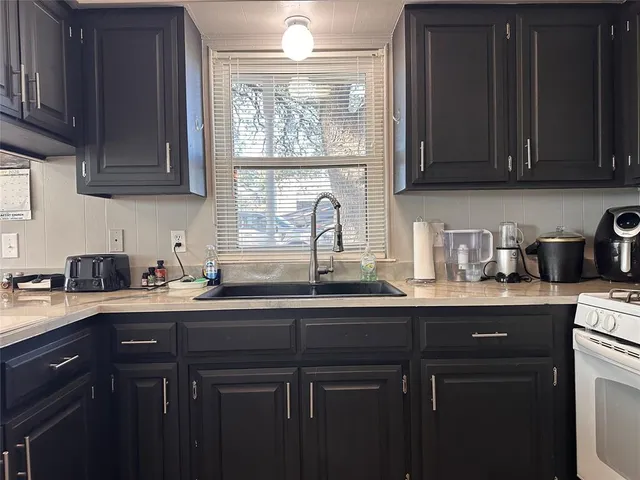 a kitchen with stainless steel appliances granite countertop a sink a stove and cabinets