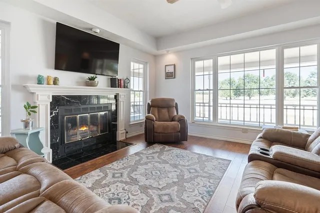 a living room with furniture a flat screen tv and a fireplace