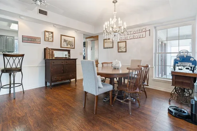 a view of a dining room with furniture a chandelier and wooden floor