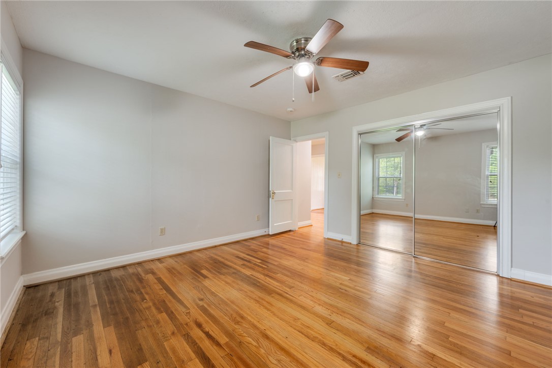 715 Inwood Drive Bryan, TX 77802 - Photo 29 of 34 an empty room with wooden floor and windows