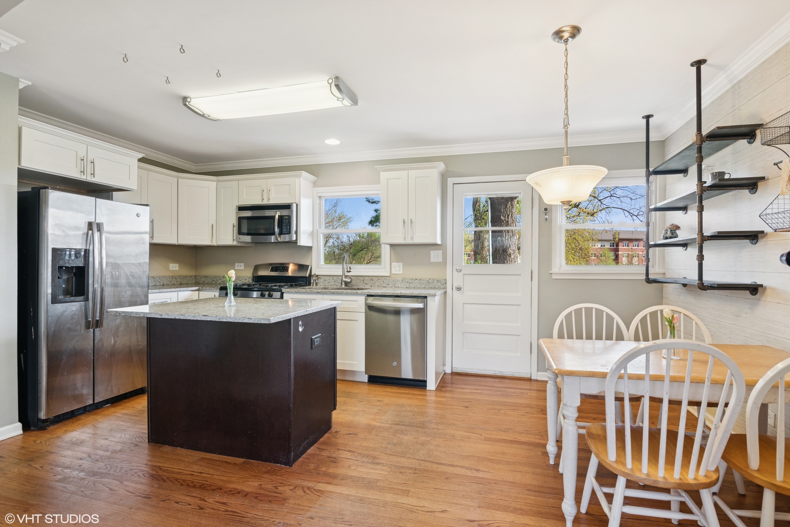 167 Glendale Street Wheeling, IL 60090 - Photo 3 of 22 a kitchen with stainless steel appliances granite countertop a refrigerator a stove a sink dishwasher and a dining table with wooden floor