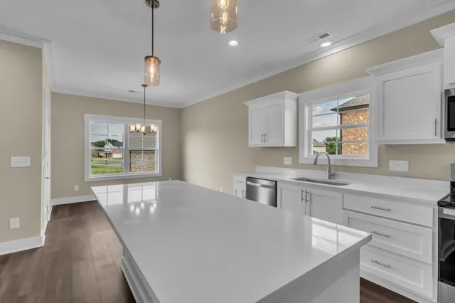 a large kitchen with kitchen island a large counter space a sink appliances and a window