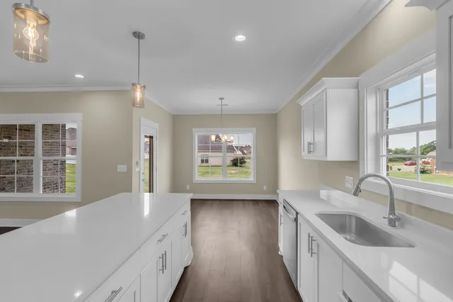 a kitchen with stainless steel appliances granite countertop a sink a stove and a wooden floors