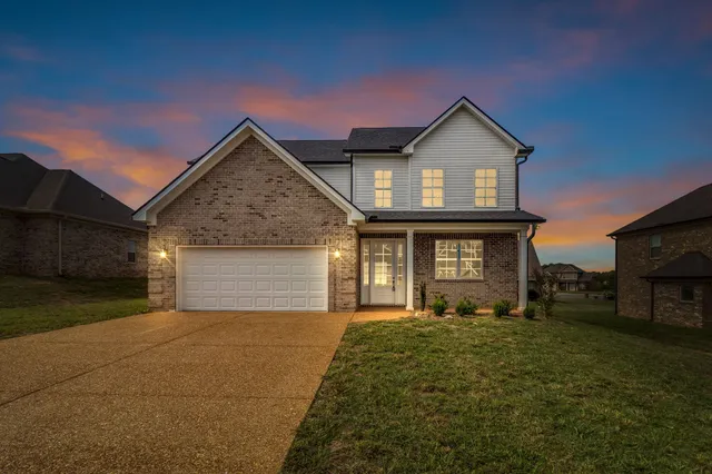 a front view of a house with yard and parking