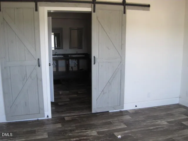 a view of a hallway with wooden floor and a cabinet