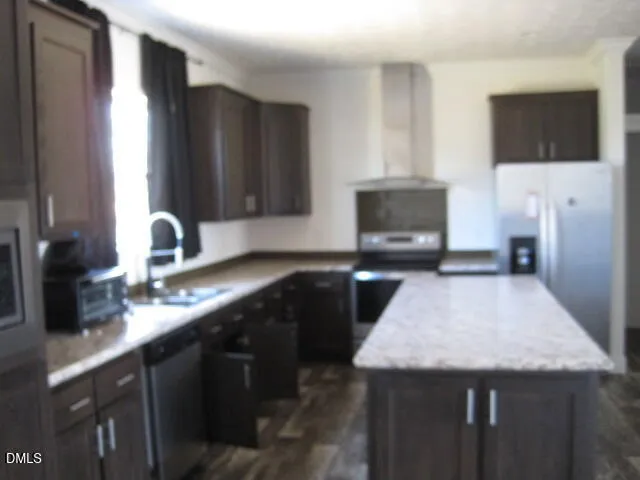 a kitchen with granite countertop a sink a stove and microwave