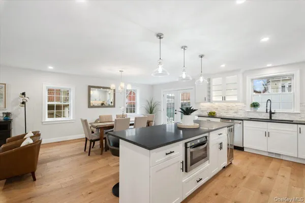 a view of a dining room and livingroom with furniture wooden floor a rug and a chandelier