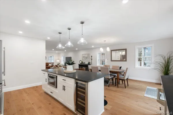 a kitchen with stainless steel appliances granite countertop a sink a refrigerator a stove and white cabinets