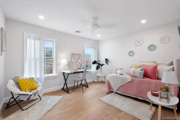 a bedroom with a bed and a potted plant on the dresser