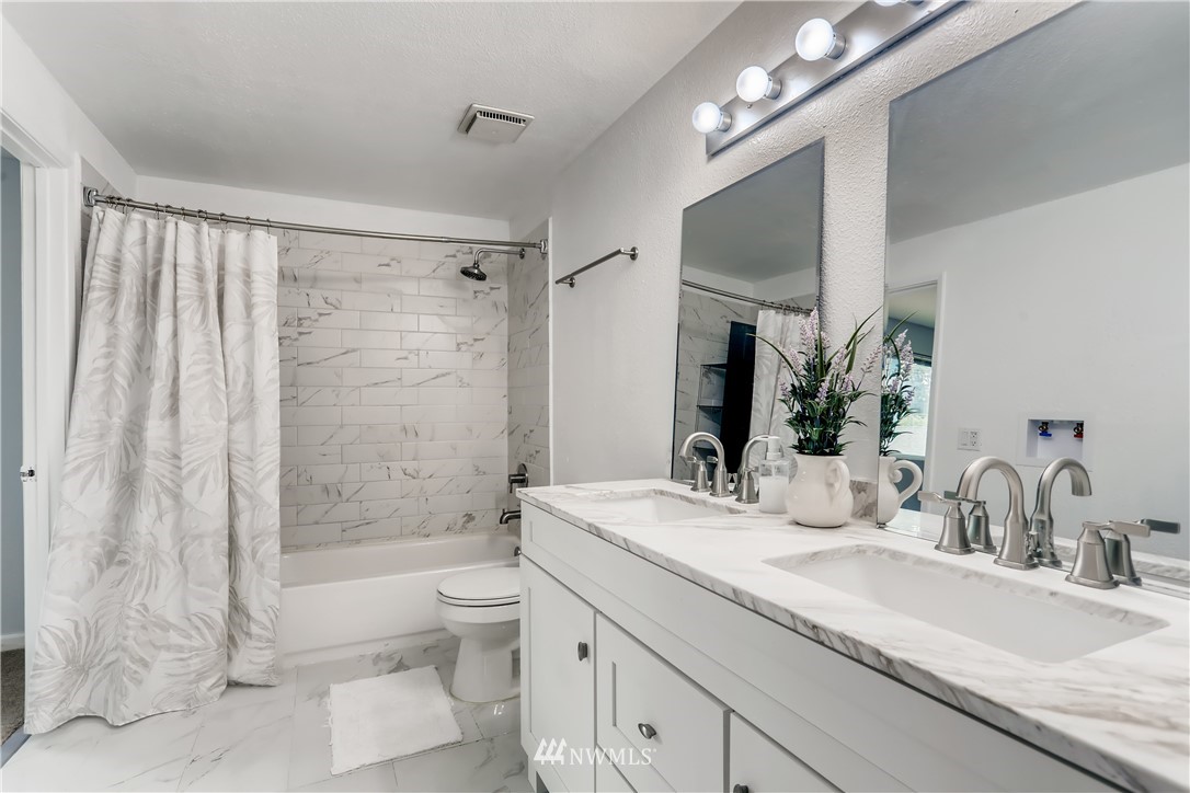 2015 181st Street Southeast Bothell, WA 98012 - Photo 11 of 20 a bathroom with a granite countertop sink a toilet a mirror and shower
