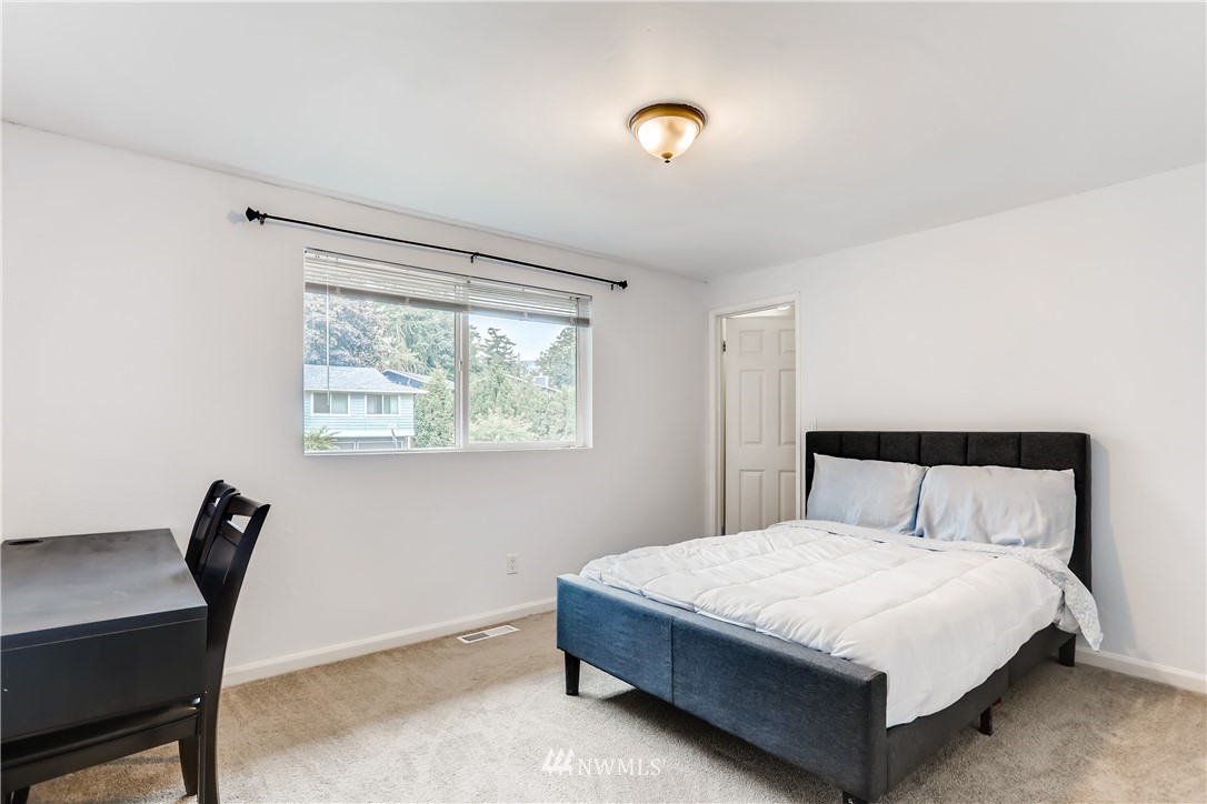 2015 181st Street Southeast Bothell, WA 98012 - Photo 12 of 20 a bedroom with a bed a table and a window