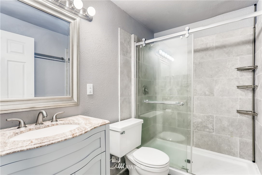 2015 181st Street Southeast Bothell, WA 98012 - Photo 17 of 20 a bathroom with a granite countertop sink toilet and shower