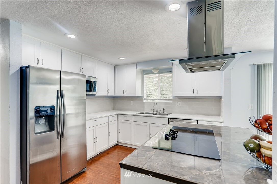 2015 181st Street Southeast Bothell, WA 98012 - Photo 3 of 20 a kitchen with stainless steel appliances granite countertop a refrigerator sink and stove