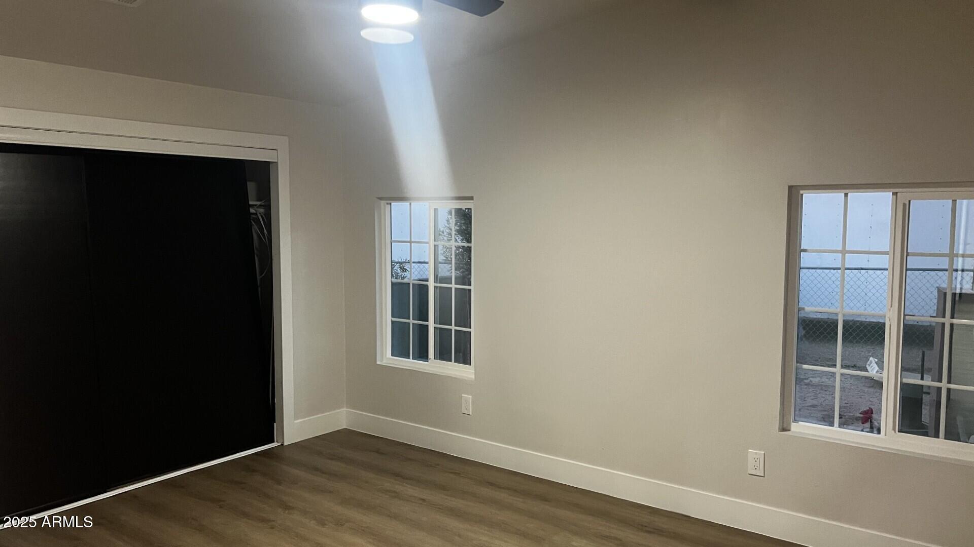2853 East Marco Polo Road Phoenix, AZ 85050 - Photo 20 of 25 an empty room with wooden floor and windows