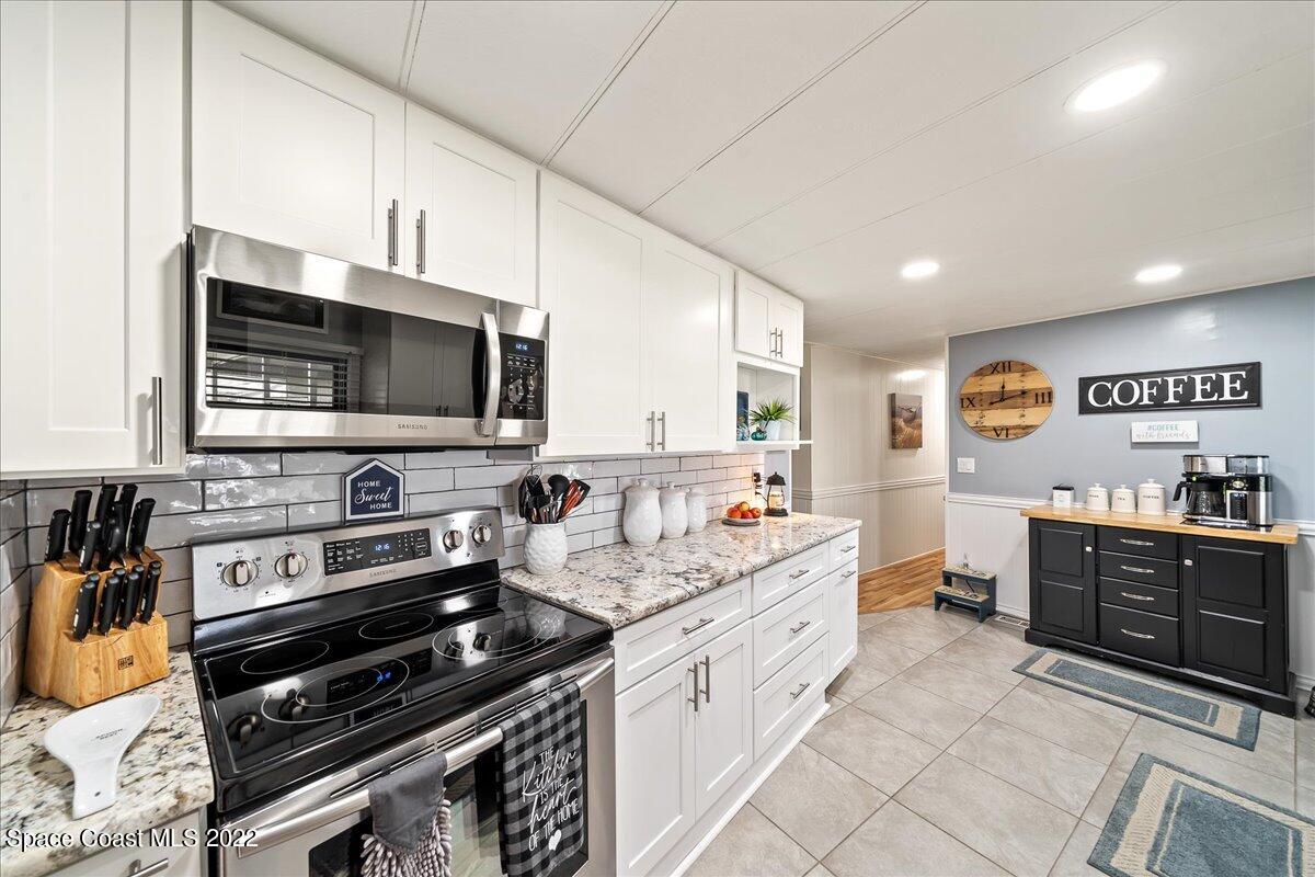 3256 Nancy Avenue Mims, FL 32754 - Photo 6 of 36 a kitchen with stainless steel appliances a stove sink microwave and cabinets
