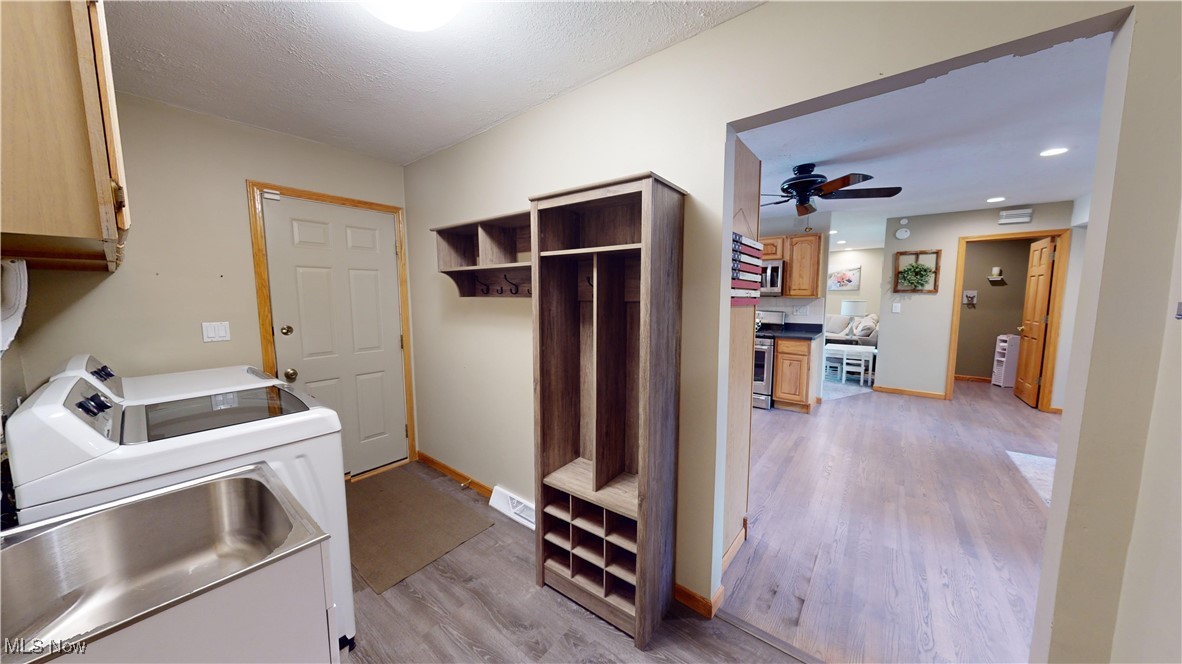 571 Ledge Road Macedonia, OH 44056 - Photo 12 of 35 Laundry room featuring washer and clothes dryer, light wood-type flooring, ceiling fan, and cabinets