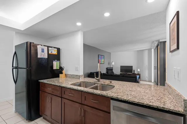 a kitchen with stainless steel appliances granite countertop a refrigerator and a sink