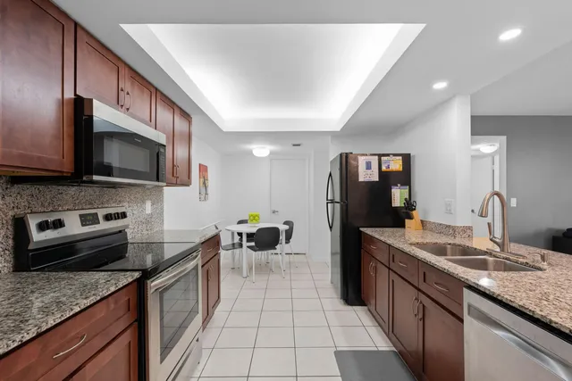 a kitchen with stainless steel appliances granite countertop a sink stove and refrigerator