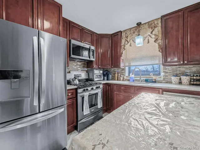 a kitchen with stainless steel appliances granite countertop a refrigerator a stove top oven a sink and dishwasher
