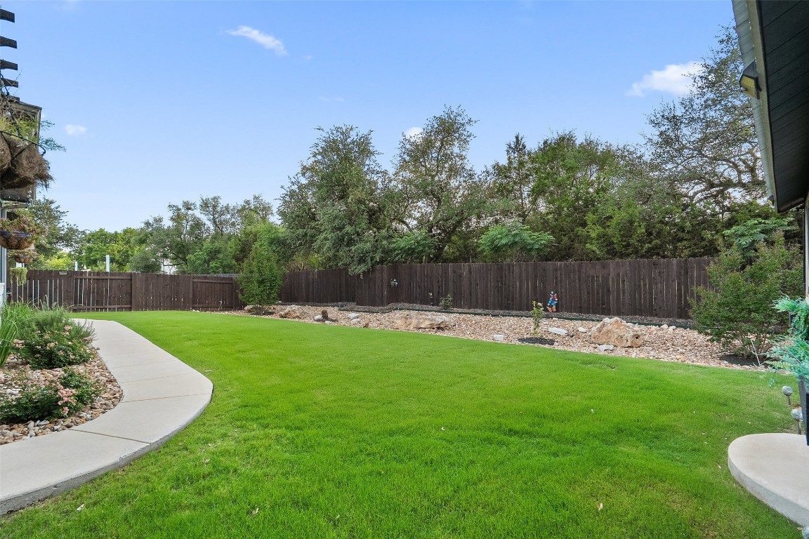 225 Escarpment Way Cedar Park, TX 78613 - Photo 27 of 40 a view of a backyard with a garden and entertaining space