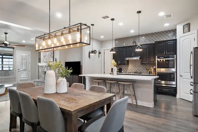 a kitchen with a table chairs refrigerator and microwave