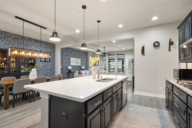 a kitchen with granite countertop a sink a counter space and stainless steel appliances