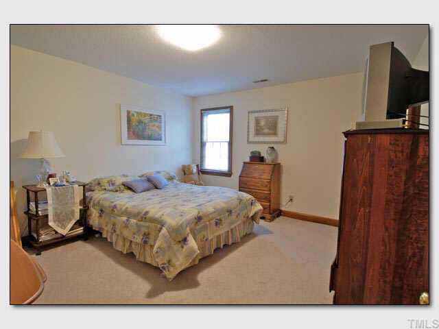 102 Skylark Way Raleigh, NC 27615 - Photo 4 of 10 a bedroom with a bed window and flat screen tv