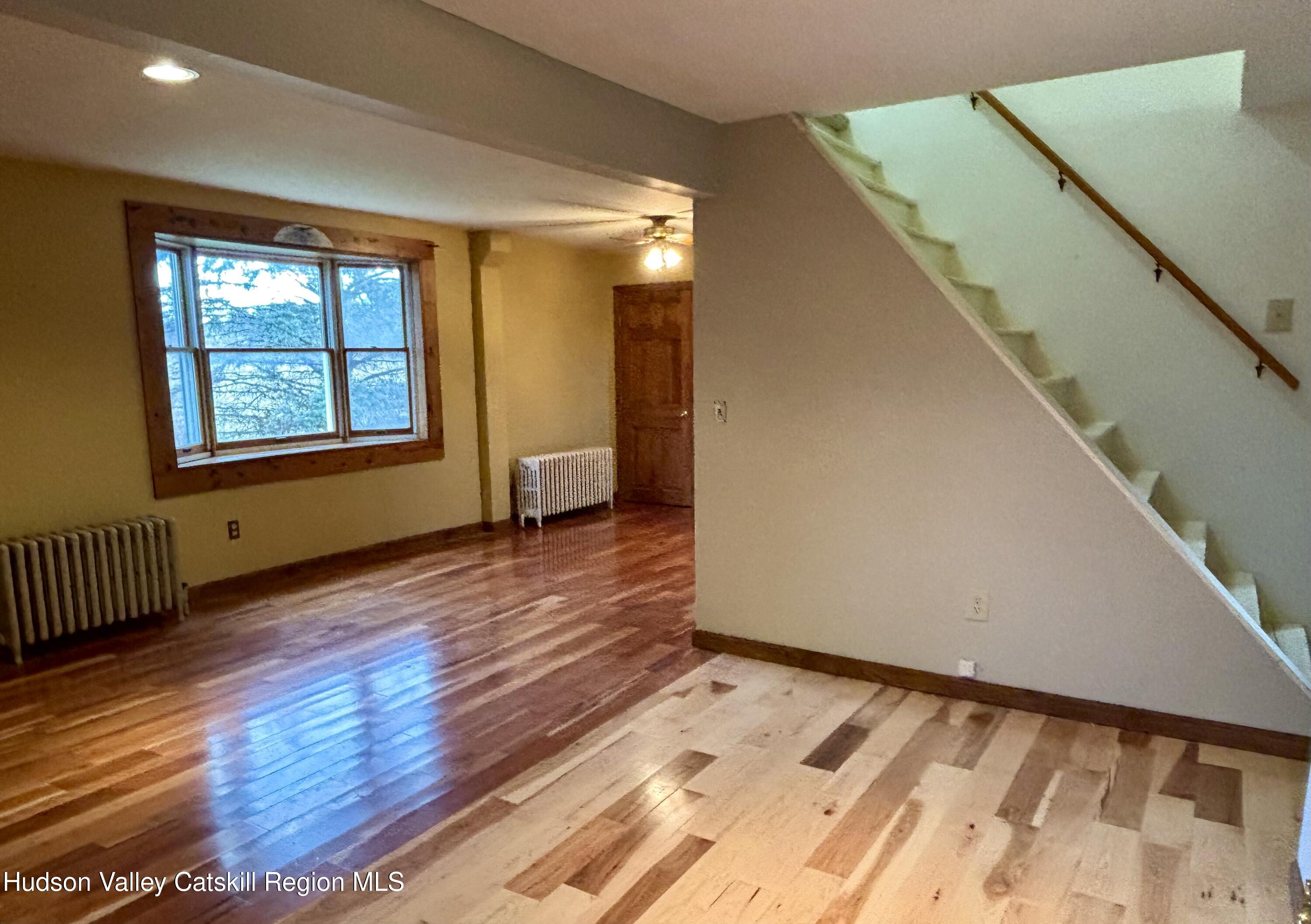 470 County Rte 28B Valatie, NY 12184 - Photo 4 of 20 a view of an empty room with wooden floor and a window