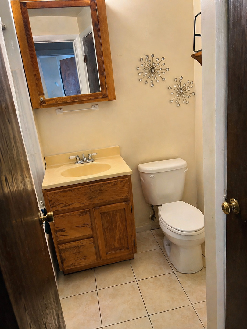 269 7th Street Wheeling, IL 60090 - Photo 19 of 30 a bathroom with a toilet sink and mirror