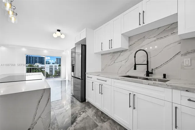 a kitchen with stainless steel appliances granite countertop a sink refrigerator and cabinets