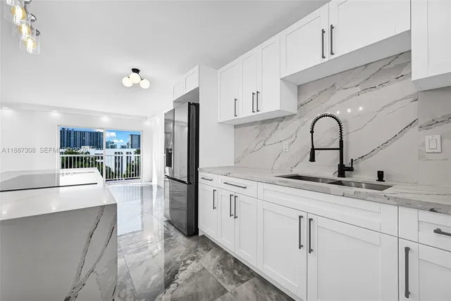 a kitchen with stainless steel appliances granite countertop a sink refrigerator and cabinets