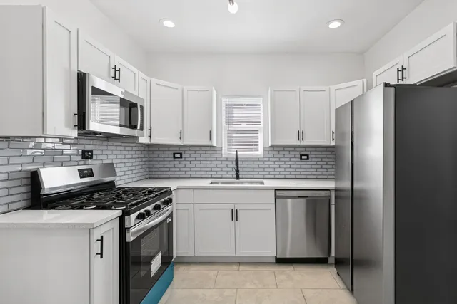 a kitchen with stainless steel appliances granite countertop a stove a sink and a refrigerator