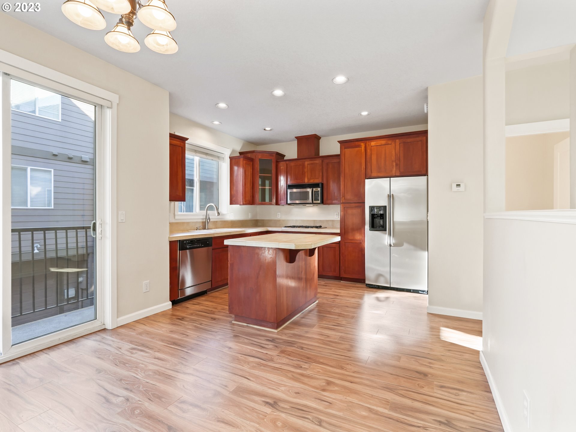 1253 Southwest 162nd Avenue Beaverton, OR 97006 - Photo 13 of 48 a large kitchen with stainless steel appliances kitchen island granite countertop a large counter top and wooden floors
