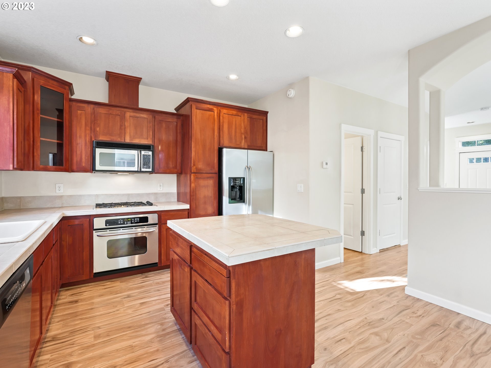 1253 Southwest 162nd Avenue Beaverton, OR 97006 - Photo 17 of 48 a kitchen with stainless steel appliances granite countertop a stove top oven a sink and a refrigerator
