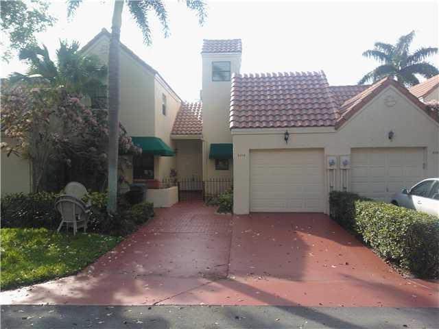 a view of a house with a yard and potted plants
