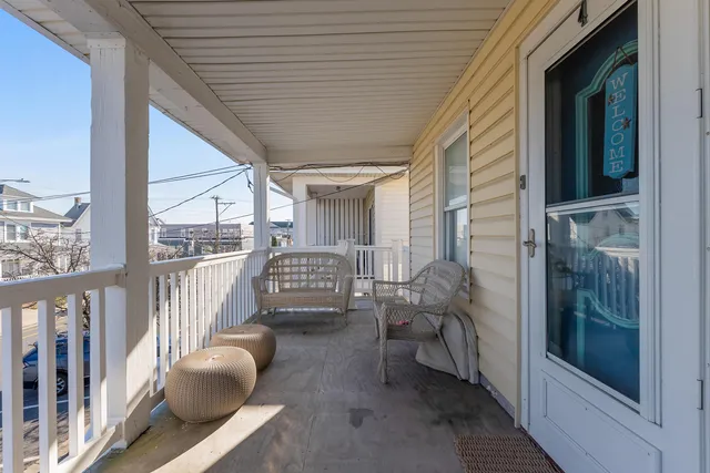 a balcony with chairs and wooden fence