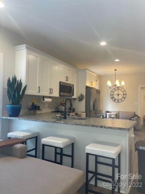 3047 Ridge Avenue Charlotte, NC 28208 - Photo 12 of 38 a kitchen with cabinets a sink and chairs