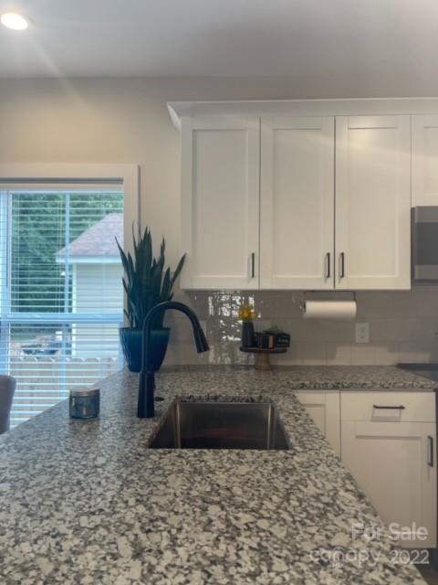 3047 Ridge Avenue Charlotte, NC 28208 - Photo 13 of 38 a bathroom with a granite countertop sink a mirror and a bathtub