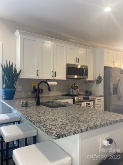 3047 Ridge Avenue Charlotte, NC 28208 - Photo 14 of 38 a kitchen with stainless steel appliances granite countertop a sink stove and refrigerator