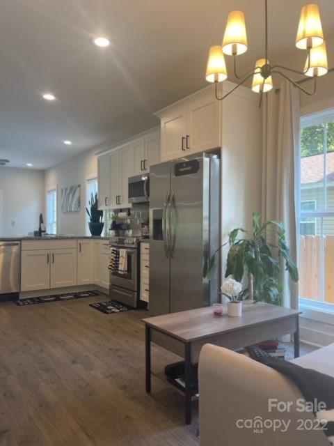 3047 Ridge Avenue Charlotte, NC 28208 - Photo 8 of 38 a kitchen with stainless steel appliances granite countertop a refrigerator a sink a stove and a dining table with wooden floor