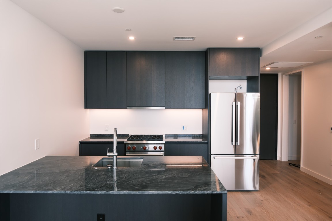 610 Davis Street, Unit 3110 Austin, TX 78701 - Photo 1 of 34 a kitchen with kitchen island a counter top and a refrigerator