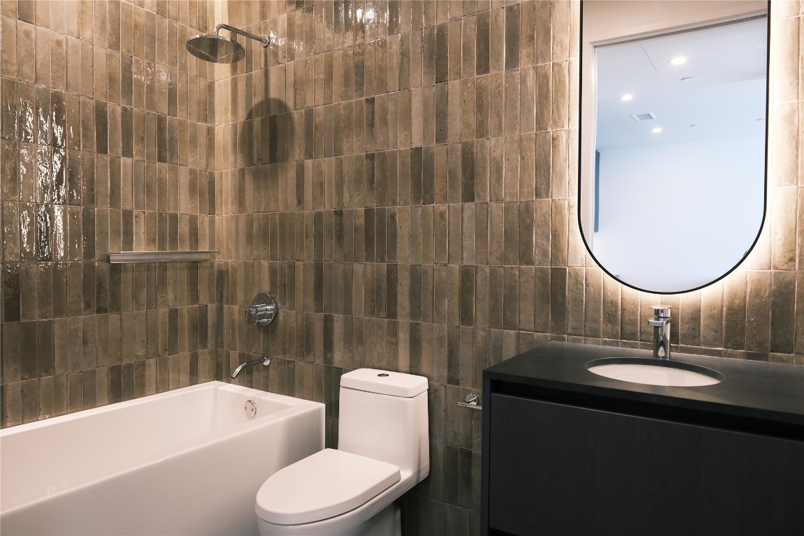 610 Davis Street, Unit 3110 Austin, TX 78701 - Photo 7 of 34 a bathroom with a sink a toilet and a mirror