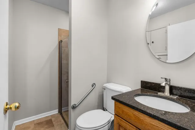 a bathroom with a granite countertop sink mirror vanity and toilet