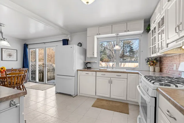 a kitchen with white cabinets and white appliances